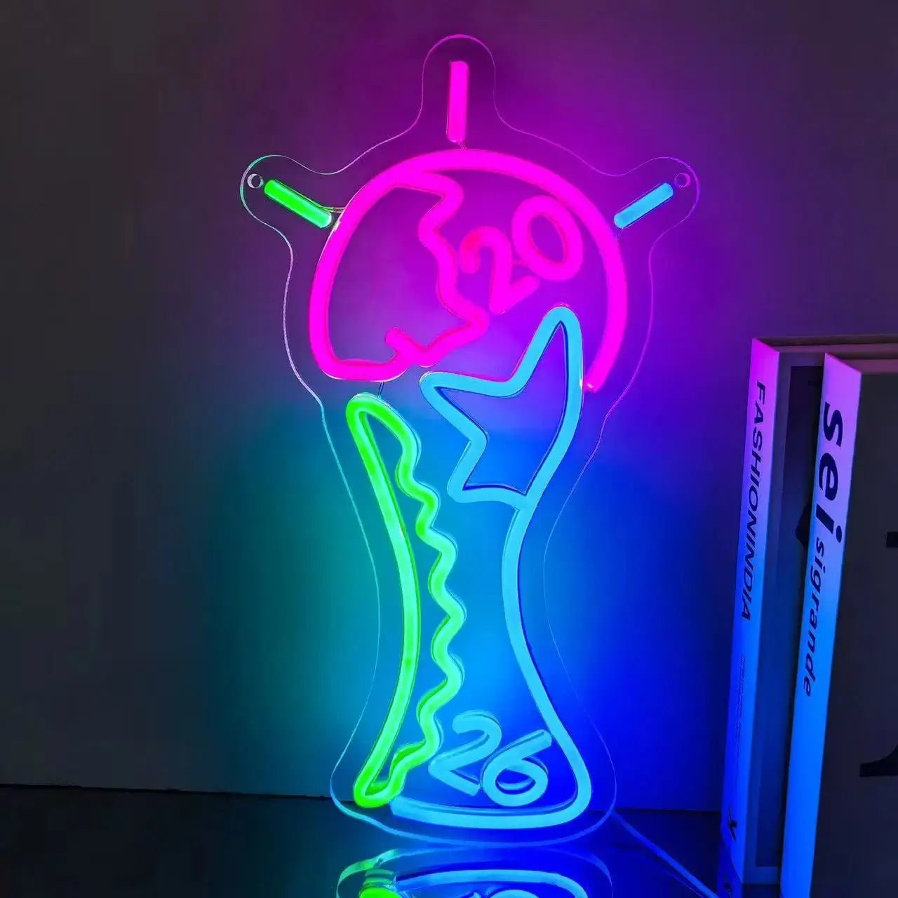 Neon World Cup trophy-shaped sign with pink, teal, green and purple glow