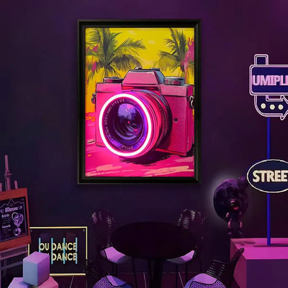 Framed LED wall art with pink camera graphic, magenta neon lens glow