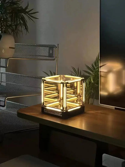 Infinity cube desk lamp on tabletop with warm golden glow through mirrored sides