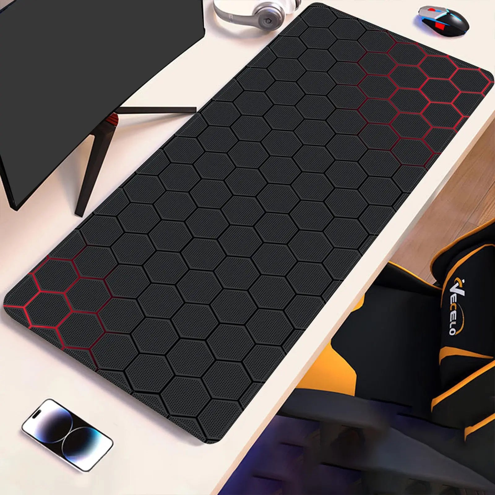 Hex-pattern technical drawing desk pad with red outline accents on dark surface