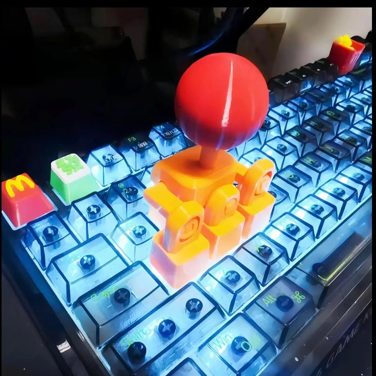 Character keycap with red round top and yellow body, placed on keyboard