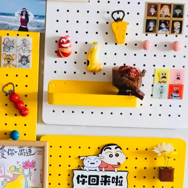White pegboard with round holes, yellow floating shelf and hanging accessories