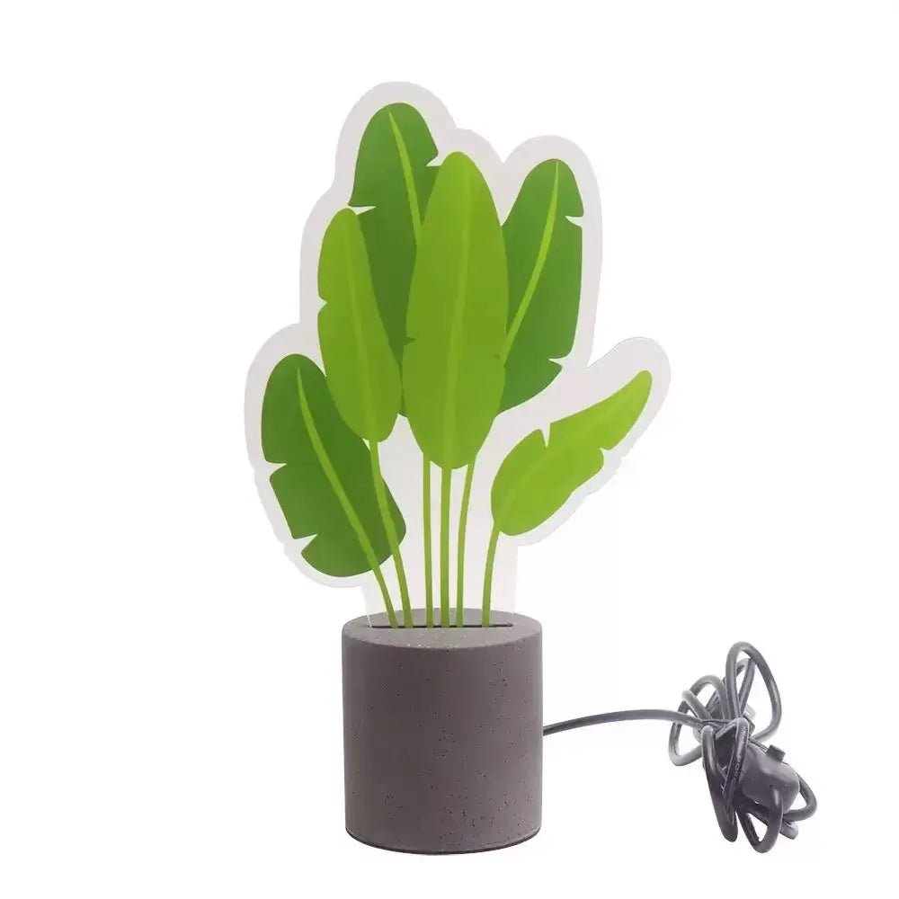 LED snake plant desk light with green leaves cutout and dark cement base