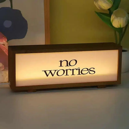 Walnut LED light box displaying “no worries” in warm light