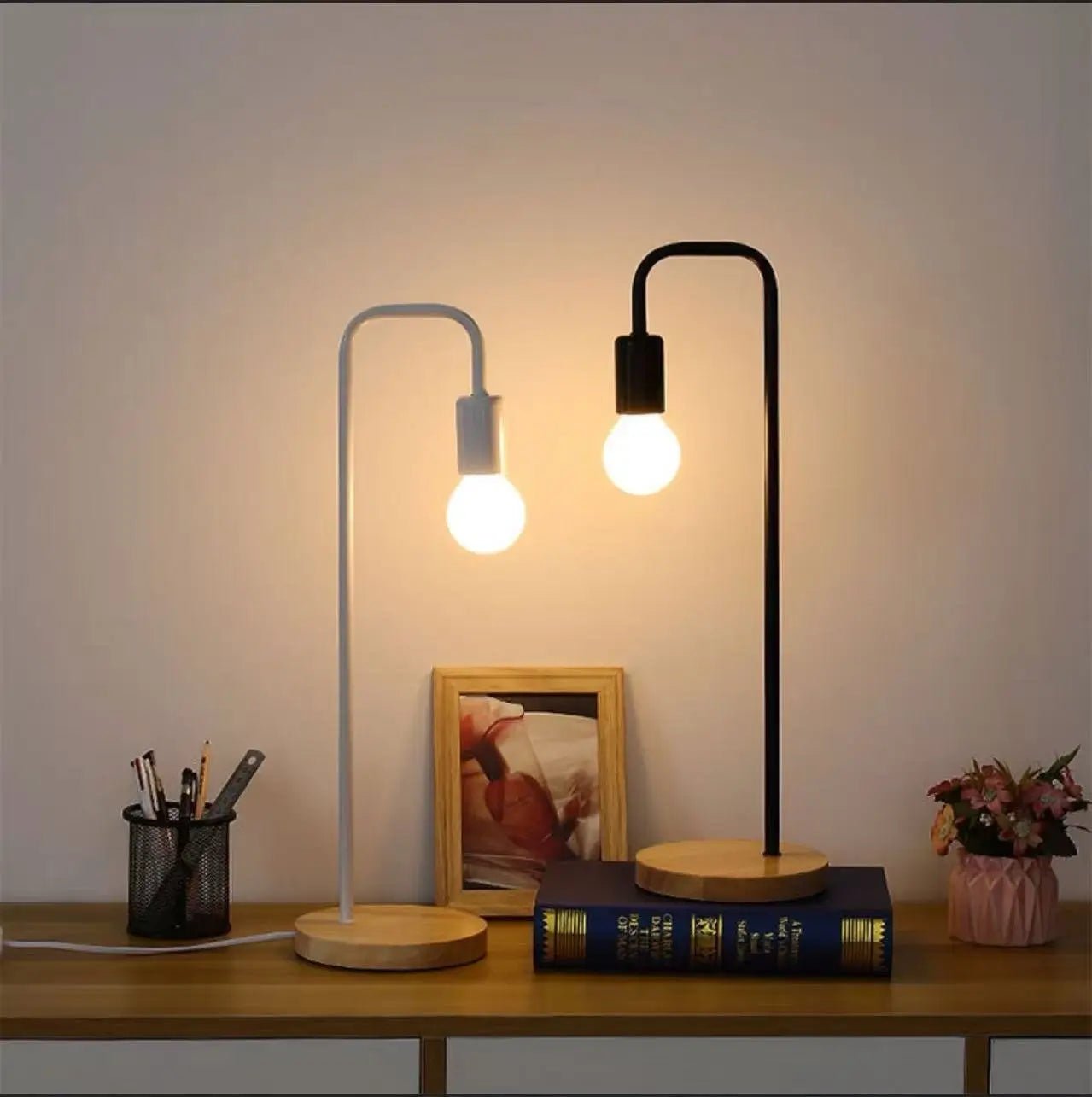 LED desk lamp with curved metal arch and exposed bulb, white and black